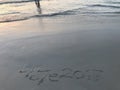 Handwritten words Ã¢â¬Åbye bye 2017Ã¢â¬Â on the beach with one lonely man Royalty Free Stock Photo